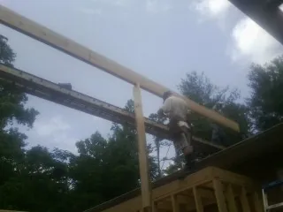 Carpenter setting a ridge beam over a new addition frame — Ice Dam Removal by Roofing Brothers in Pray